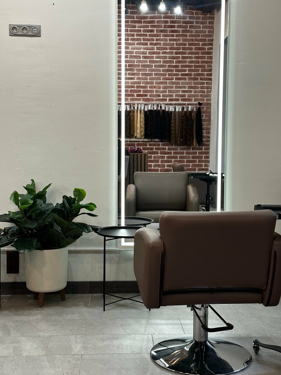 Кресло мастера, зеркало с подсветкой и растения в студии Staff Hair